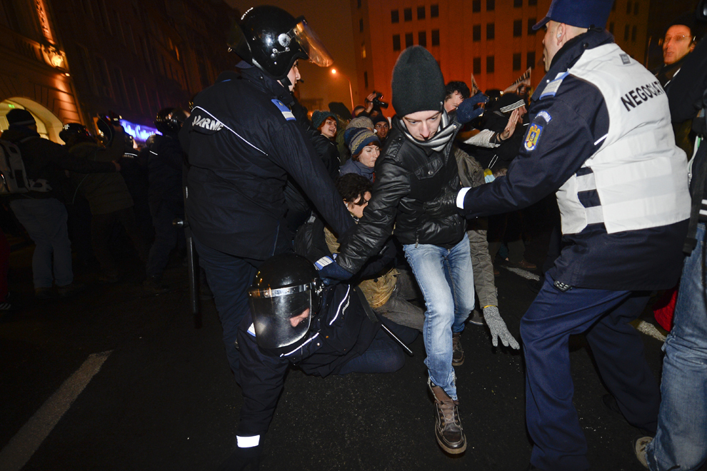 Persoane, care manifestează împotriva modificărilor aduse Codului penal, încearcă să treacă de cordonul de jandarmi, în Bucureşti, duminică, 15 decembrie 2013.