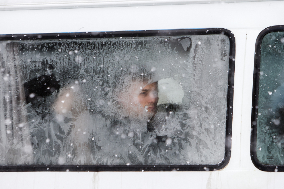 Un tânăr priveşte prin geamul îngheţat al unui microbuz, în timpul ninsorilor puternice din Chişinău, Republica Moldova, joi, 30 ianuarie 2014.