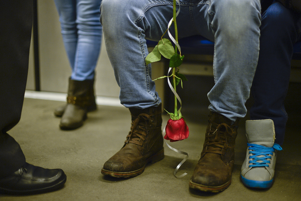 Un tânăr ţine în mâini un trandafir, într-un vagon de metrou, în Bucureşti, vineri, 14 februarie 2014.