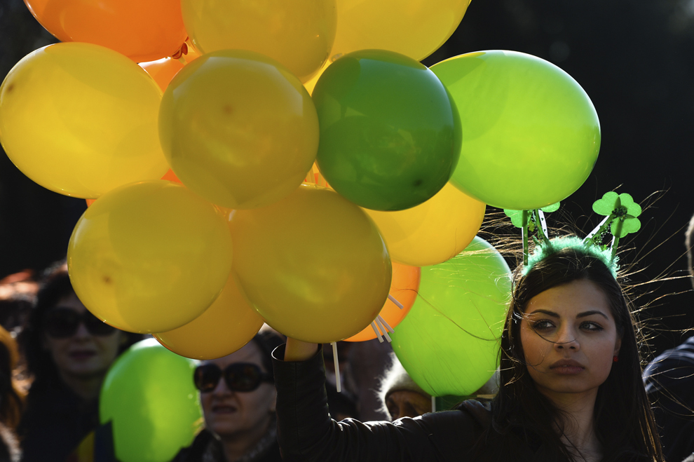 O tânără ţine în mână baloane colorate în timpul unei parade organizate cu ocazia zilei de St. Patrick, în Bucureşti, duminică, 16 martie 2014.