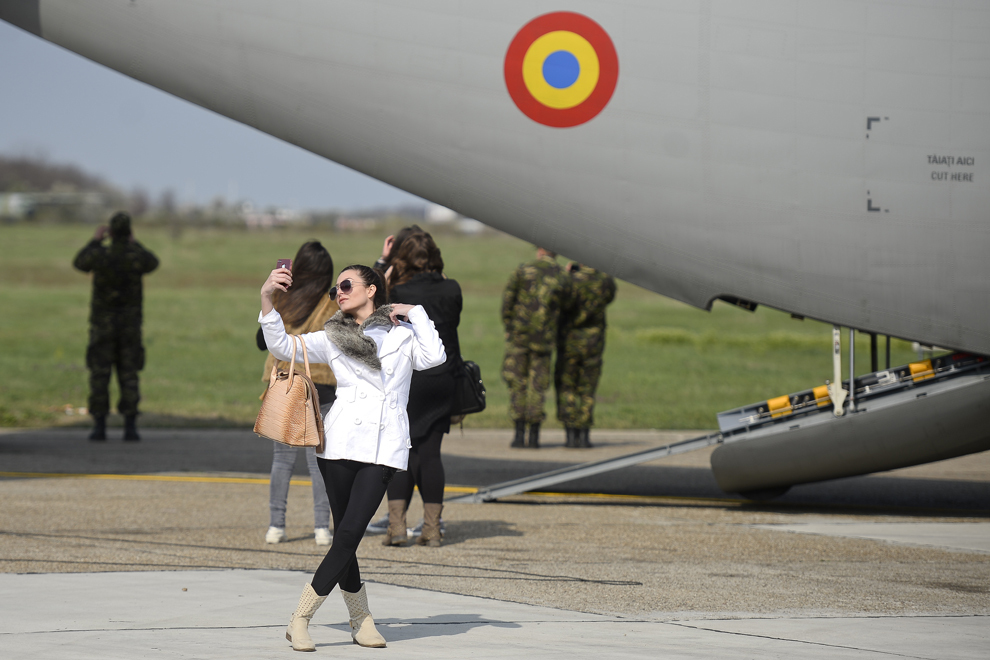 O tânără se fotografiază lângă un avion C-130 Hercules, în timpul Zilei Porţilor Deschise, organizată la Baza 90 Transport Aerian cu ocazia aniversării a 10 ani de la aderarea României la NATO, în Otopeni, judeţul Ilfov, miercuri, 2 aprilie 2014.