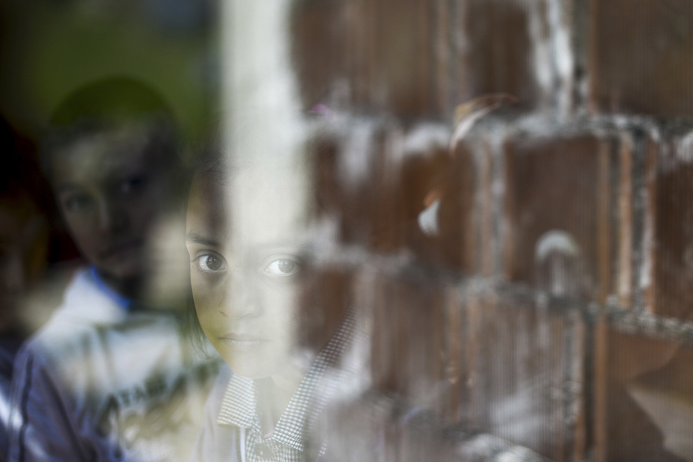 Diana, opt ani, priveşte prin geamul Centrului de Zi pentru Copii, condus de Asociaţia Lumină pentru Romi, în Boldeşti-Scăeni, Prahova, miercuri, 8 mai 2014.