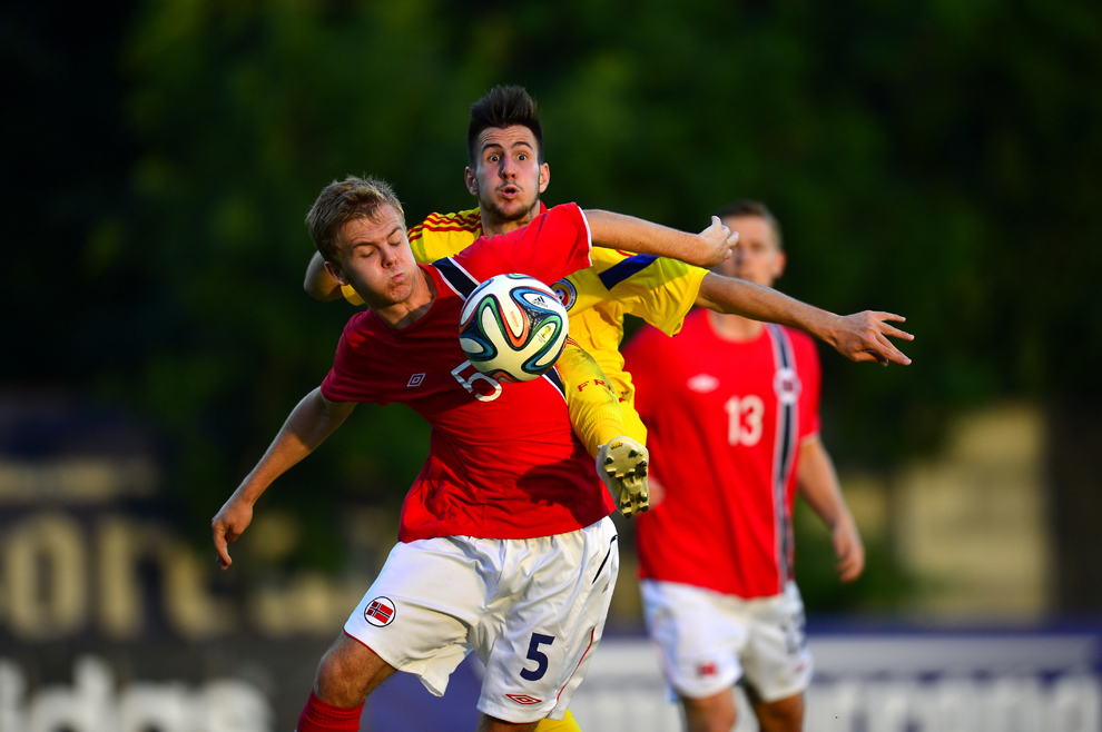 Constantin Adrian Păun-Alexandru, de la echipa de fotbal a României U19, se luptă pentru balon cu Stian Stray Molde, de la selecţionata Norvegiei, în meciul din ultima etapa a Turului de Elită Under 19, disputat în Mogoşoaia, marţi, 10 iunie 2014.