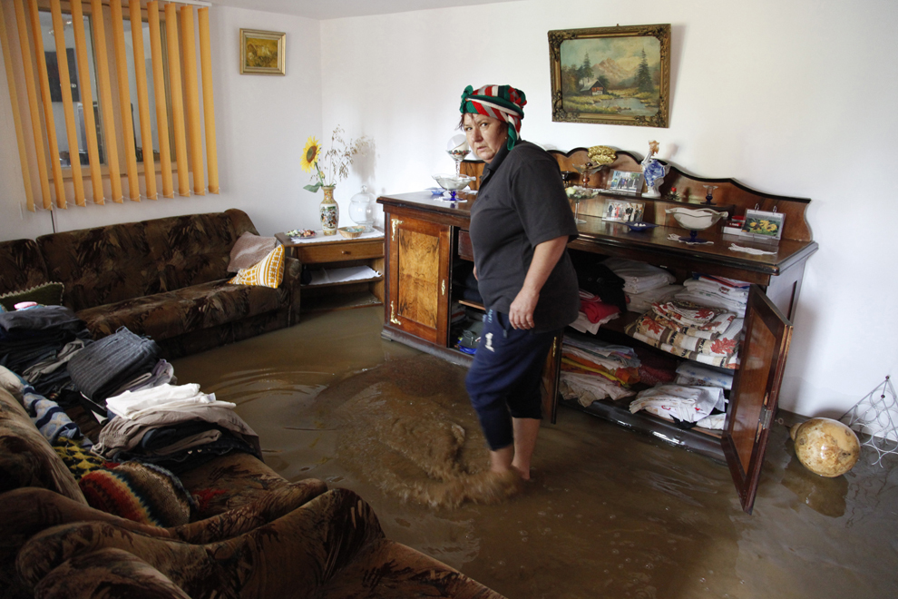 Aurelia Dinu merge printr-o cameră inundată în noaptea de miercuri spre joi, în comuna Verneşti din judeţul Buzău, joi, 10 iulie 2014.