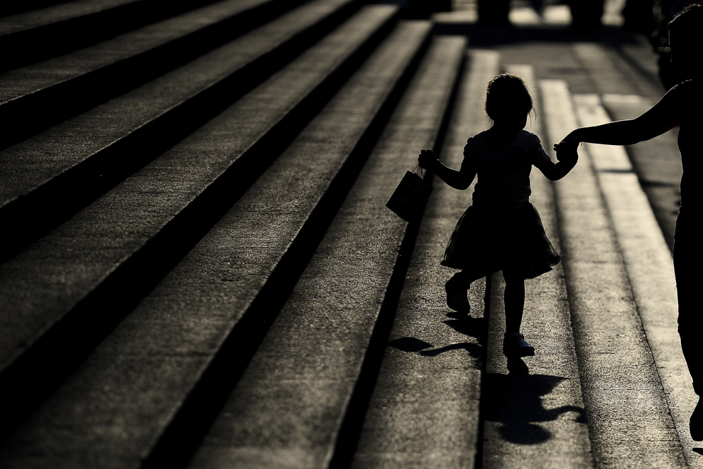 O fetiţă este ajutată de mama ei să coboare treptele din faţa Curţii de Apel Bucureşti, marţi, 5 august 2014.