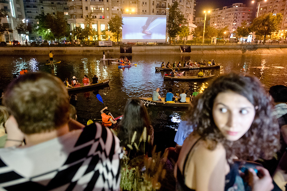 Spectatori urmăresc o proiecţie specială pe râul Dâmboviţa - Dj Set Experimental: Omnibus Anonimul 10 din cadrul Festivalului Anonimul, în Bucureşti, miercuri, 13 august 2014. 