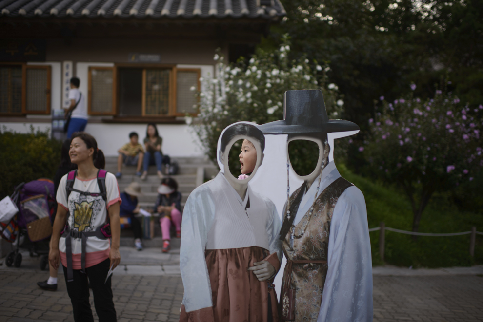 Un copil aşteaptă să pozeze lângă un panou cu decupaje reprezentând costume tradiţionale coreene Hanbok, în timpul sărbătorii Chuseok, în Seul, Coreea, marţi, 9 septembrie 2014. 