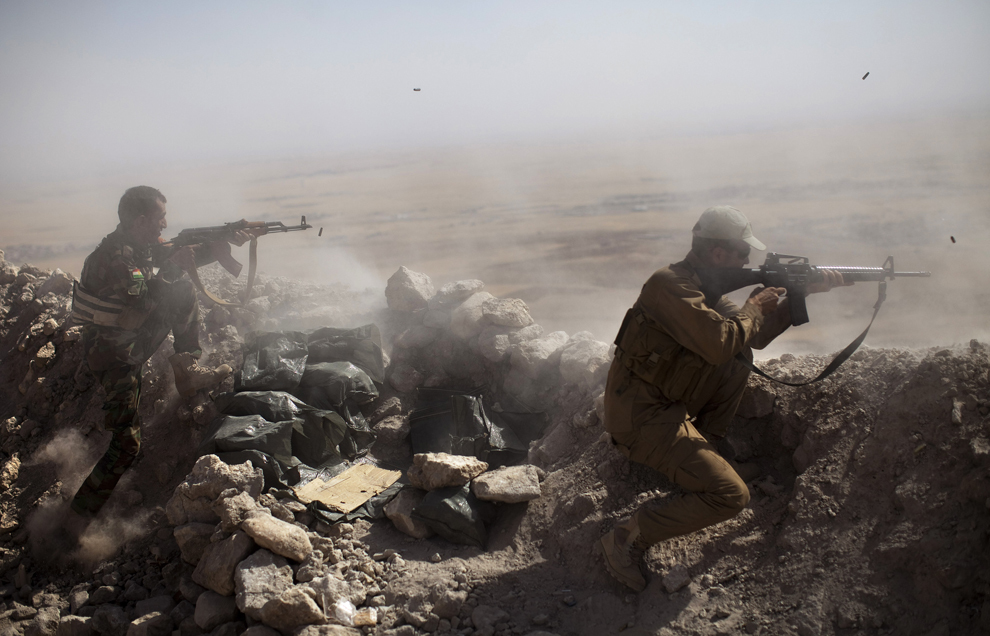 Luptători irakiano-kurzi Peshmega trag în direcţia militanţilor IS (Islamic-State), pe muntele Zardak, la aproximativ 25 de km de Mosul, Irak, marţi, 9 septembrie 2014. 