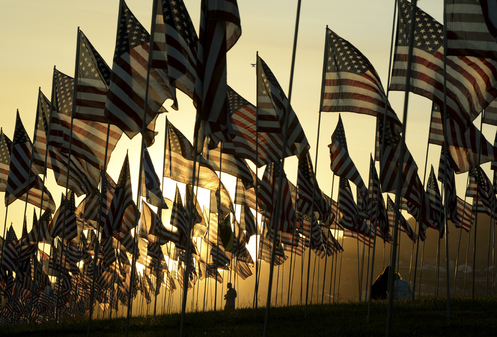 Persoane se plimbă printre steagurile Statelor Unite ale Americii, ridicate de studenţi şi membri ai staff-ului Universitaţii din Pepperdine, în memoria victimelor atacului terorist din 11 septembrie 2001, în Malibu, marţi 9 septembrie 2014.