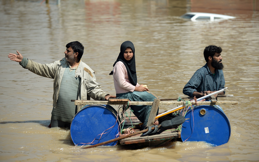 Bărbaţi kaşmiri transportă pe o plută improvizată o fată sinistrată în urma inundaţiilor din Sringar, India, marţi, 10 septembrie 2014.