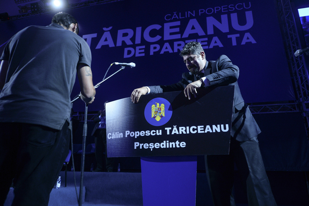 Un bărbat aşează o pancartă, pe care este scris "Călin Popescu Tăriceanu Preşedinte", pe pupitrul de la care a vorbit candidatul la Preşedinţia României, Călin Popescu-Tăriceanu, la Palatul Parlamentului, în Bucureşti, vineri, 26 septembrie 2014.
