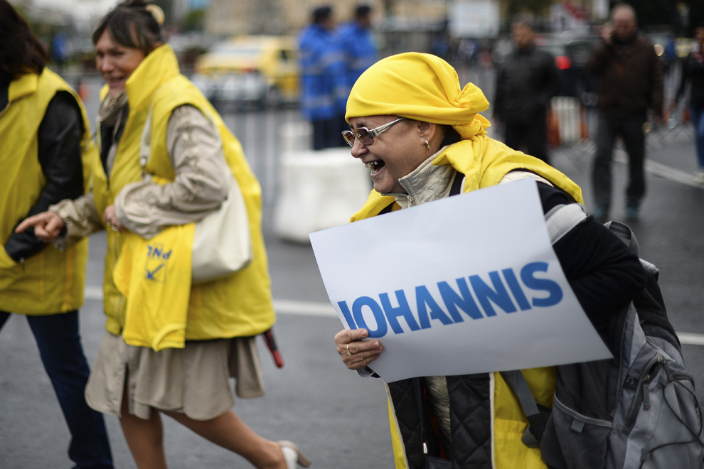 O simpatizantă a ACL reacţionează în timp ce ţine în mâna o pancartă cu textul "IOHANNIS", înaintea începerii evenimentului de lansare a candidaturii la Preşedinţia României a lui Klaus Iohannis, în Piaţă Victoriei din Bucureşti, sâmbătă, 27 septembrie 2014.