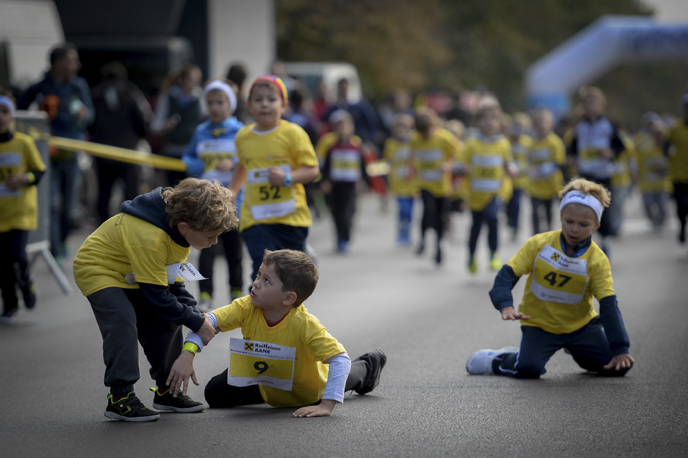Un copil care a căzut este ajutat de un alt copil să se ridice, în timpul "Cursei Copiilor" ce s-a desfăşurat în cadrul "Maratonului Internaţional Bucureşti", în Bucureşti, sâmbătă, 4 octombrie 2014.