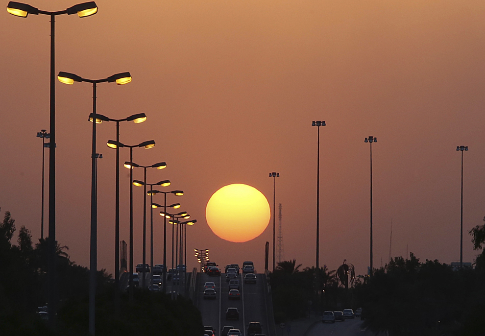 Soarele apune deasupra autostrăzii principale din Kuweit, miercuri, 8 octombrie 2014.