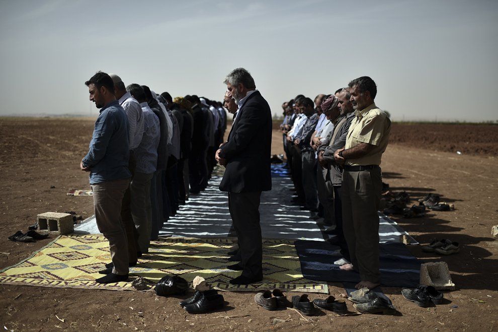 Kurzi sirieni şi turci se roagă în timpul rugăciunii de vineri, la graniţa turco-siriană, la periferia oraşului Suruc, provincia Şanliurfa, Turcia, vineri, 10 octombrie 2014.
