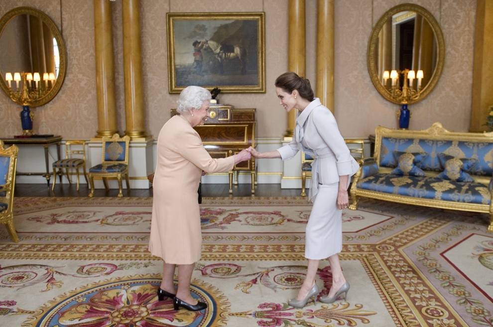 Regina Marii Britanii, Elizabeth a II-a îi oferă actriţei Angelina Jolie (D) însemnele titlului onorific Dame Grand Cross of the Most Distinguished Order of St Michael and St George,  în sala 1844 de la palatul Buckingham din Londra, vineri, 10 octombrie 2014. 