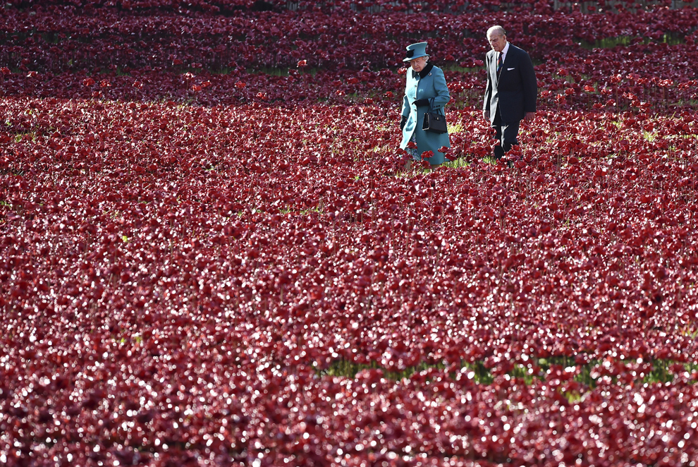 Regina Marii Britanii, Elizabeta a II-a (S) alături de soţul său, prinţul Philip (D), Duce de Edinburgh, vizitează instalaţia de maci ceramici intitulată "Blood Swept Lands and Seas of Red", în Londra, Marea Britanie, joi, 16 octombrie 2014.