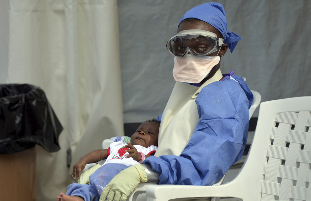 O asistentă liberiană ţine in braţe un copil infectat cu virusul Ebola, la centrul de tratament al ONG-ului Medecins Sans Frontieres (Medici fara Frontiere), în Monrovia, Liberia, sâmbătă, 18 octombrie 2014. 