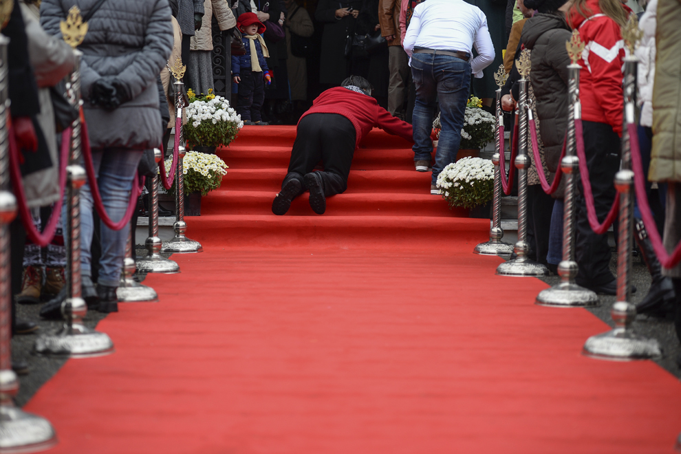 O persoană aranjează covorul roşu, în aşteptarea Patriarhului Daniel şi a Preafericitului Părinte Patriarh Teofil al III-lea al Ierusalimului, care vor inaugura Centrul Rezidenţial pentru Persoane Vârstnice "Sfântul Silvestru", în Bucureşti, duminică, 26 octombrie 2014.