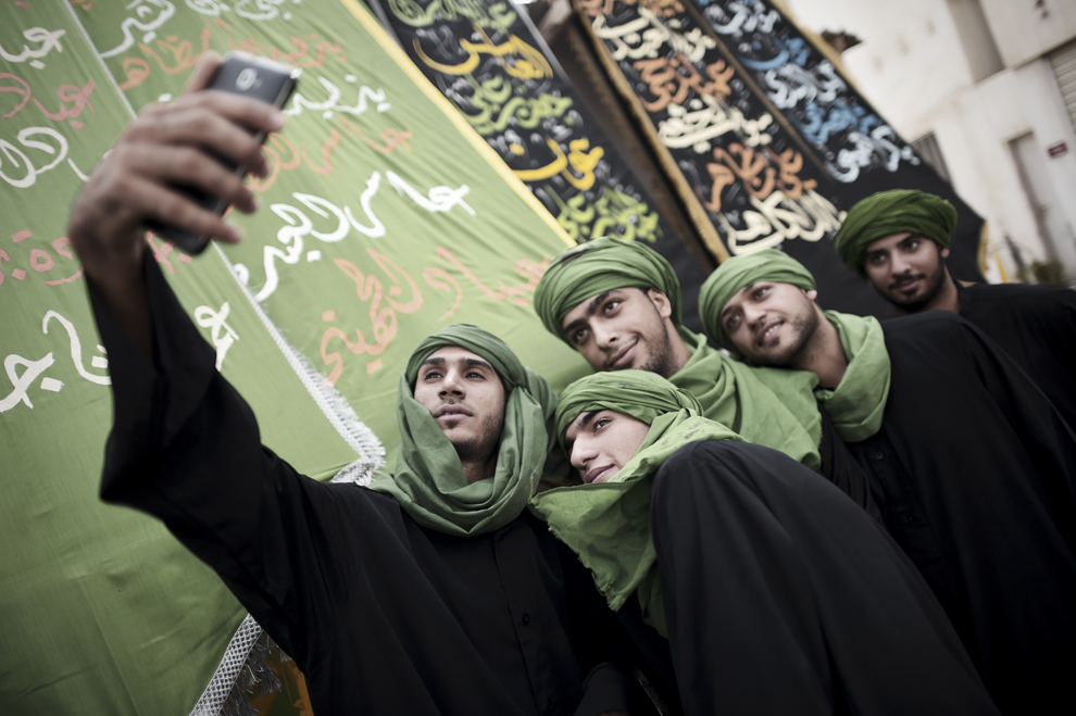 Musulmani şiiţi pozează pentru un selfie, în timpul ceremoniei de comemorare a Zilei de Ashura, în satul Sanabis, la vest de Manama, Bahrain, marţi, 4 noiembrie 2014.