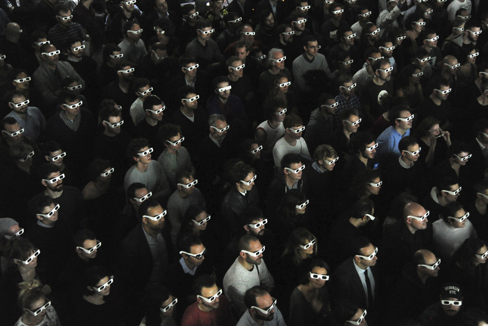 Spectatori care poartă ochelari 3D privesc un spectacol live al formaţiei Kraftwerk , în Paris, joi, 6 noiembrie 2014.