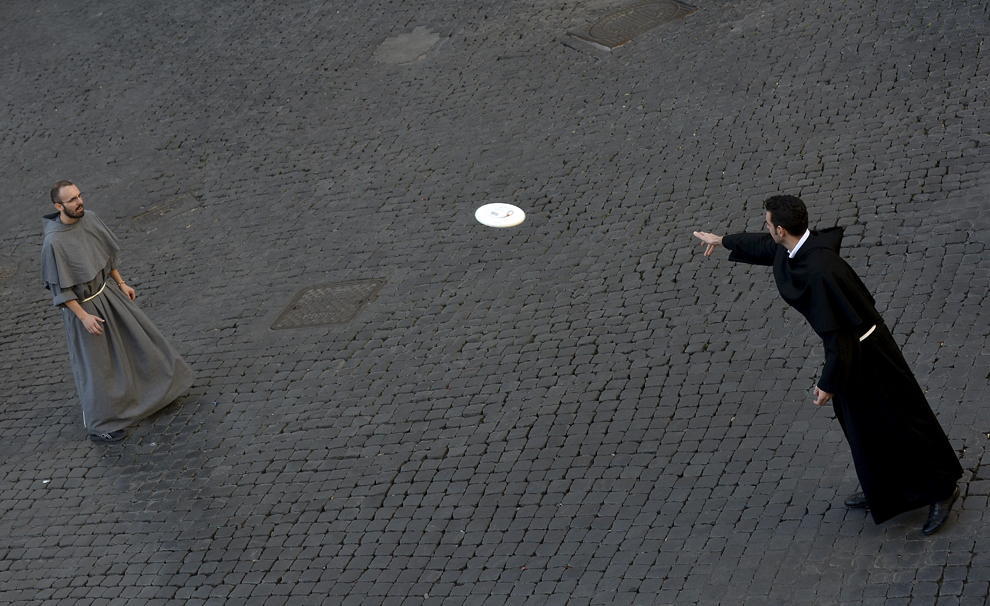 Călugări se joacă cu un disc frisbee în piaţa Santi Apostoli din Roma, duminică, 9 noiembrie 2014.