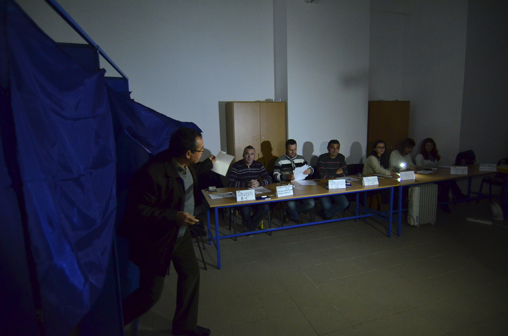 Un alegator isi exercita dreptul de vot in timpul unei pene de curent, in turul al doilea al alegerilor prezidentiale, in Craiova, duminica, 16 noiembrie 2014.
