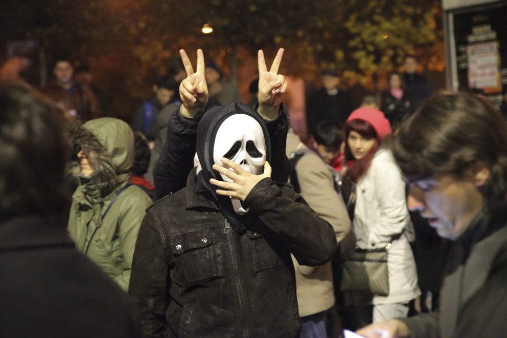 O persoană care poartă o mască Ghostface, personaj din filmul Scream, participă la mitingul din timpul celui de-al doilea tur al alegerilor prezidenţiale, în Piaţa Universităţii din Bucureşti, duminică, 16 noiembrie 2014.