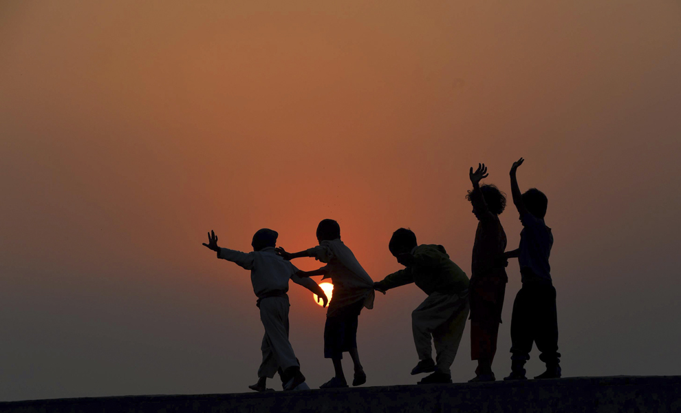 Copii se joacă pe acoperişul unei case, la periferia oraşului Lahore, Pakistan, miercuri, 19 noiembrie 2014. 