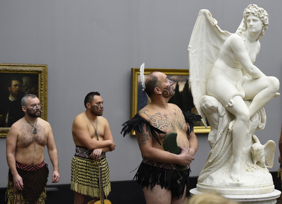 Membri ai grupului Ngati Ranana privesc statueta "Hexe" (Vrăjitoare, 1874) a sculptorului german Carl Cauer, în Berlin, marţi 18 noiembrie 2014.