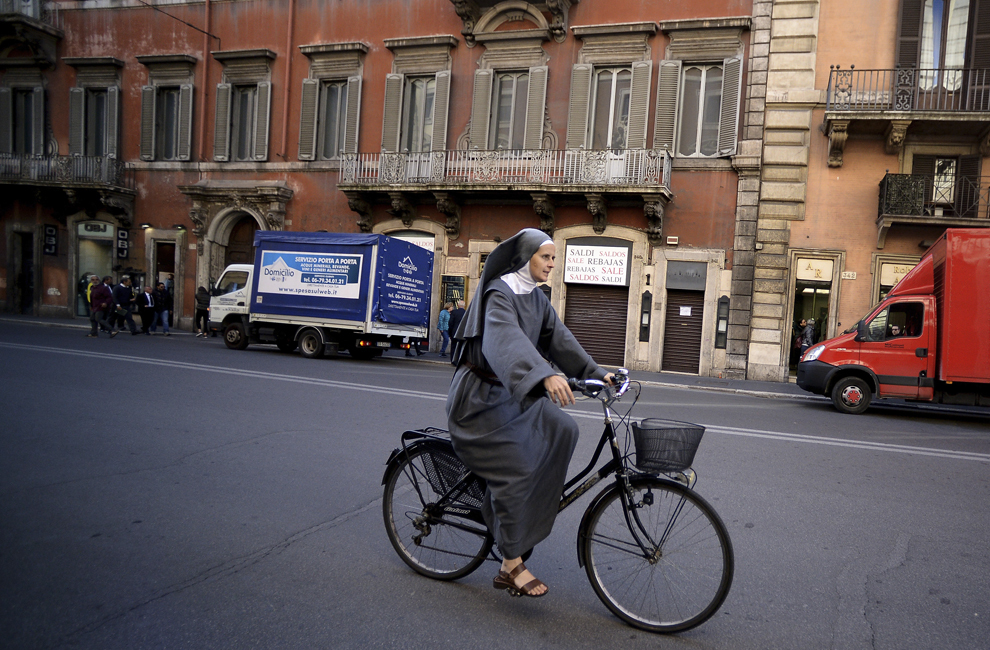 O călugăriţă străbate o stradă din Roma pe bicicletă, joi, 20 noiembrie 2014.