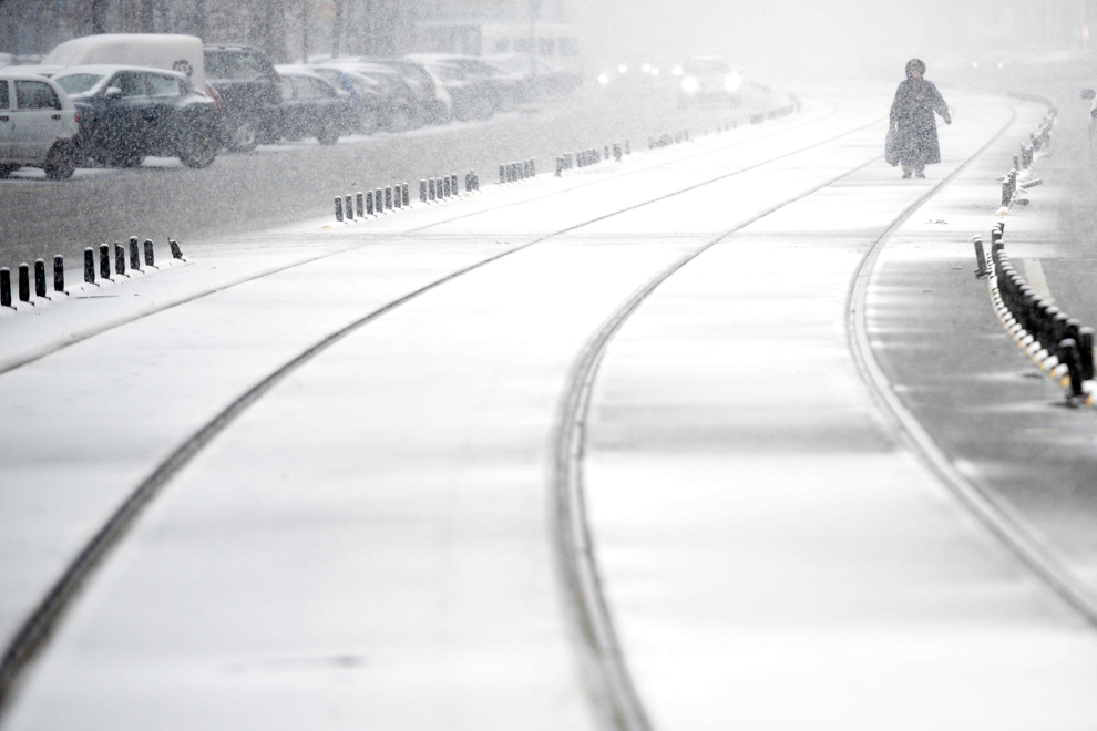 O persoană merge prin ninsoare, în Bucureşti, sâmbătă, 27 decembrie 2014. 
