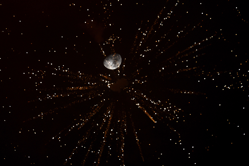 Luna poate fi văzută printre artificii pe cerul Bucureştiului, aprinse cu ocazia Revelionului, în Piaţa Constituţiei, joi, 1 ianuarie 2015.