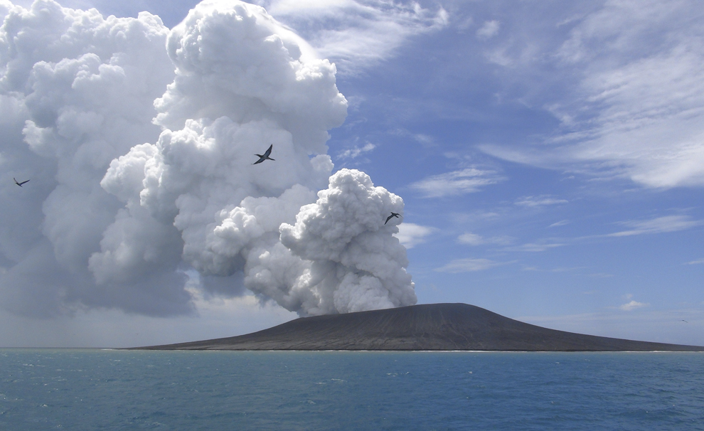 Păsări zboară în apropiere de un vulcan ce emite aburi şi gaze, la aproximativ 65 de km nord-vest de capitala Tongăi, Nuku’alofa, sâmbătă, 17 ianuarie 2015.