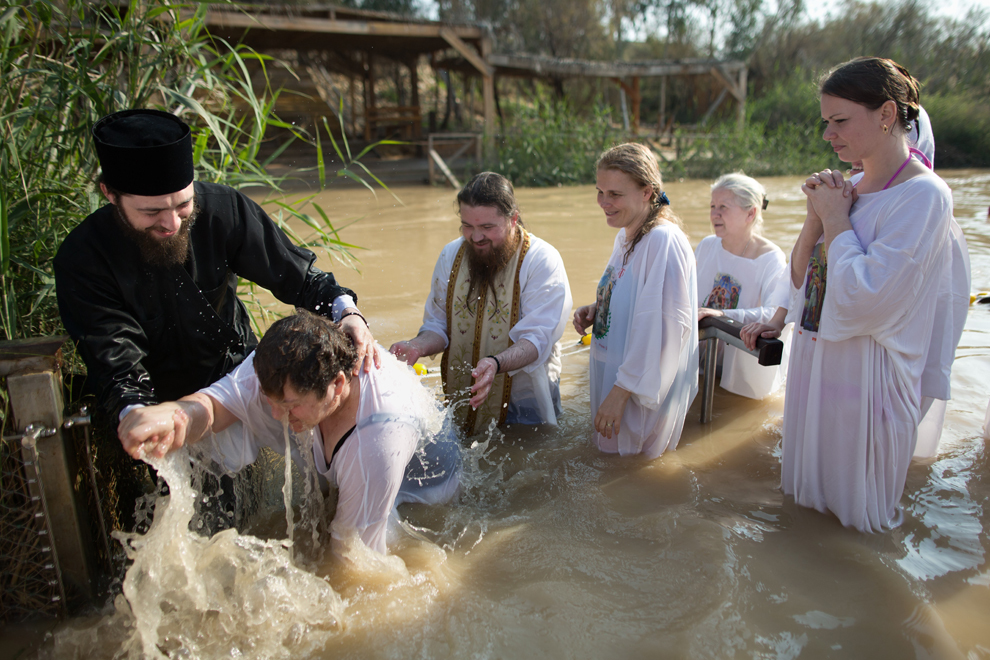 Preoţi creştini-ortodocşi botează pelerini în apele râului Iordan, în timpul Bobotezei, în Qasr el Yahud, Cisiordania, duminică, 18 ianuarie 2015.