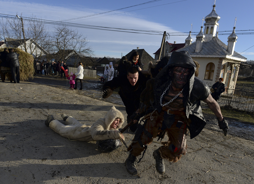 Români  îmbrăcaţi în costume tradiţionale se manifestă în timpul sărbătorii „Malanka”, în satul  Krasnoilsk, regiunea Cernăuţi, Ucraina, joi 15 ianuarie 2015.