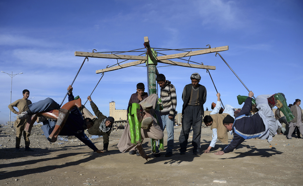 Copii afgani se joacă într-un carusel dintr-un bâlci aflat la periferia Mazar-i-sharif, vineri, 16 ianuarie 2015.
