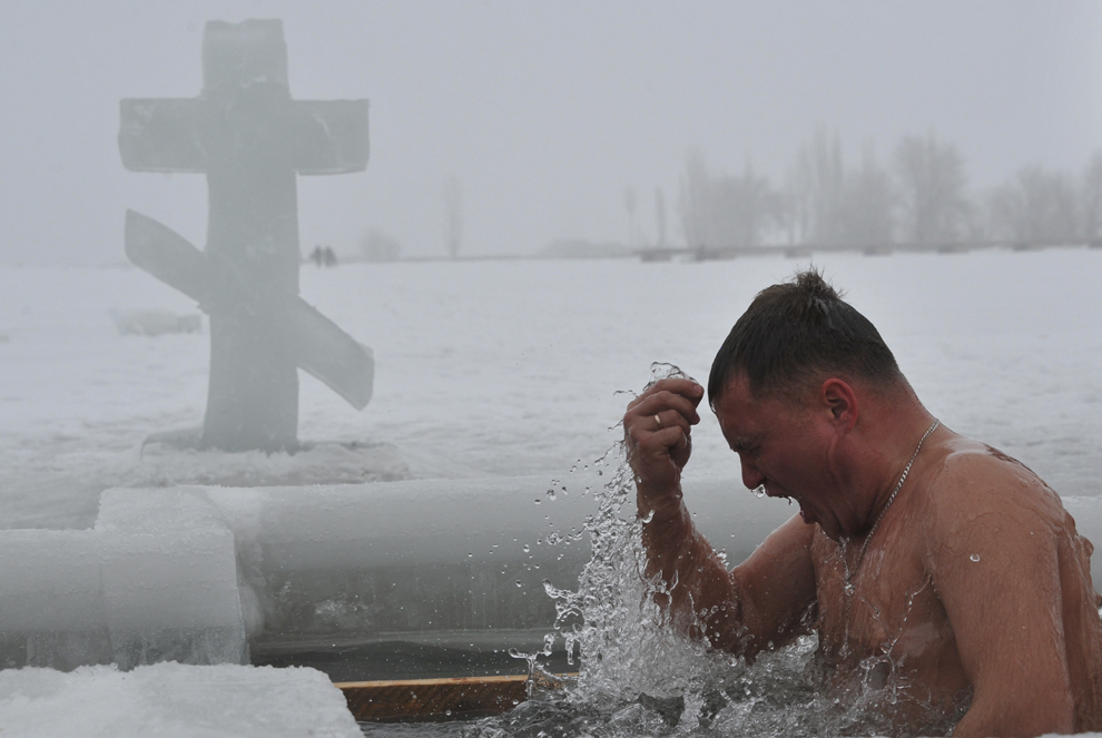Un credincios ortodox îşi face cruce în timp ce intră în apele îngheţate ale unui lac, în timpul celebrării Bobotezei, în satul Sretinka, Kârgâstan, luni, 19 ianuarie 2015.