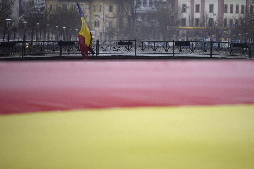 O persoana participă la un flash-mob, organizat de Platforma Unionistă “Acţiunea 2012”, în cadrul căruia este desfăşurat un tricolor, lat de cinci metri, peste râul Dâmboviţa, pentru a marca 156 de ani de la Unirea Principatelor Române, pe Podul de la Piaţa Naţiunilor Unite, în Bucureşti, sâmbătă, 24 ianuarie 2015.