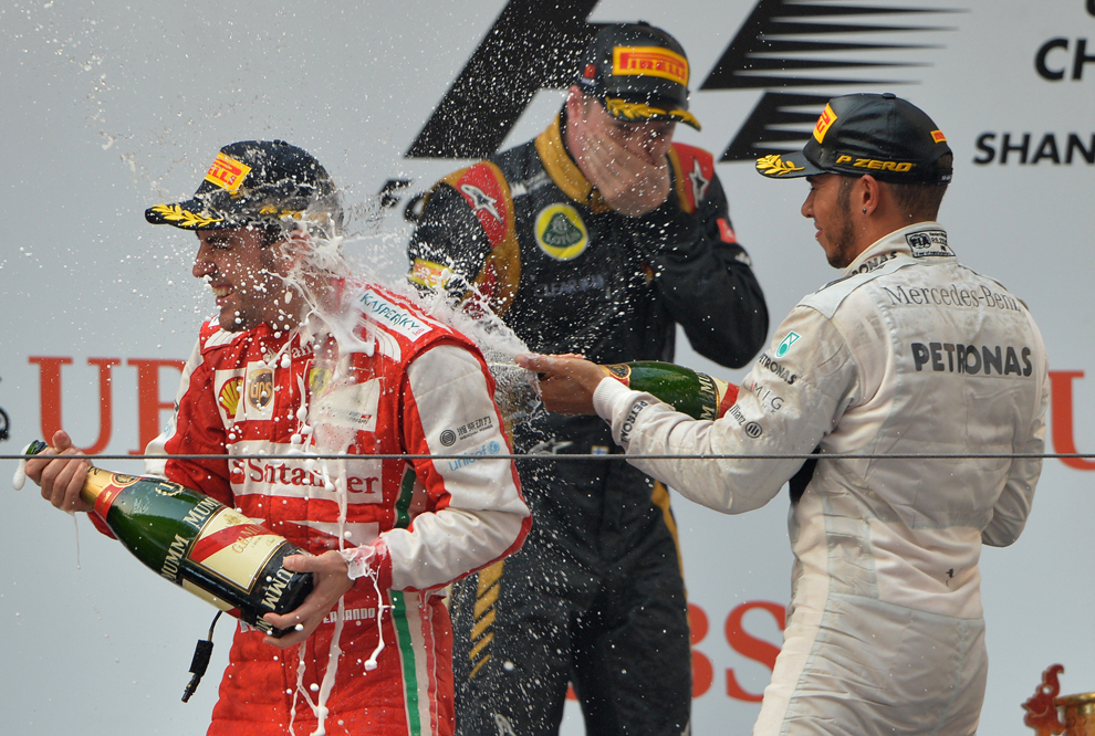 Pilotul echipei Ferrari, Fernando Alonso (S), sărbătoreşte pe podium câştigarea Marelui Premiu de Formula 1 al Chinei, alături de câştigătorii locului doi şi trei, Kimi Raikkonen (C) de la Lotus şi Lewis Hamilton (D) de la Mercedes, în Shanghai, duminică, 14 aprilie 2013. 