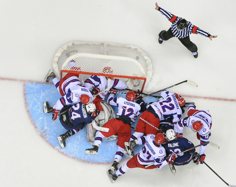 Un arbitru gesticulează în spatele porţii apărată de portarul rus Igor Shestyorkin, indicând că nu a fost gol, în timpul semifinalei Campionatului Mondial de Hochei pe Gheaţă U18 IIHF, în Soci, vineri, 26 aprilie 2013. Naţionala Statelor Unite a invins-o pe cea a Rusiei cu scorul de 4 la 3. 