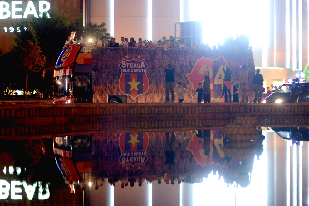 Jucătorii stelişti, ţinând în mâini trofeul Ligii I, sosesc în Piaţa Constituţiei într-un autocar descoperit, pentru a sărbători câştigarea celui de-al 24-la titlu din istorie, marţi, 28 mai 2013. 