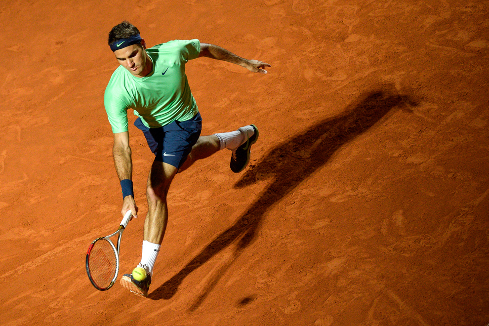 Jucătorul elveţian de tenis Roger Federer returnează o minge francezului Gilles Simon, în cadrul ATP Tennis Open din Roma, joi, 16 mai 2013. 