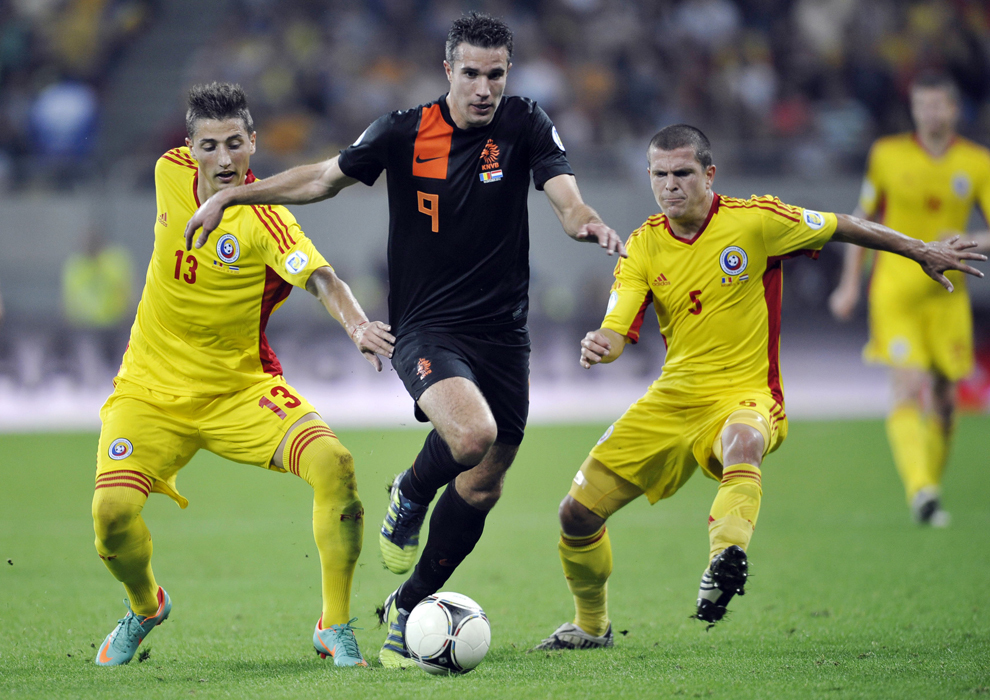 Gheorghe Grozav (S) şi Alexandru Bourceanu (D), de la selecţionata României, se luptă pentru balon cu Robin van Persie (C), de la naţionala Olandei, în timpul meciului din grupa D a preliminariilor Cupei Mondiale 2014, în Bucureşti, marţi, 16 octombrie 2012. 