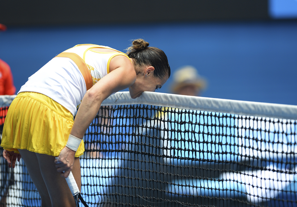 Italianca Flavia Pennetta muşcă fileul după ce a pierdut un punct în timpul meciului de simplu împotriva germancei Angelique Kerber, în ziua a şaptea a turneului de tenis Australian Open, în Melbourne, duminică, 19 ianuarie 2014.