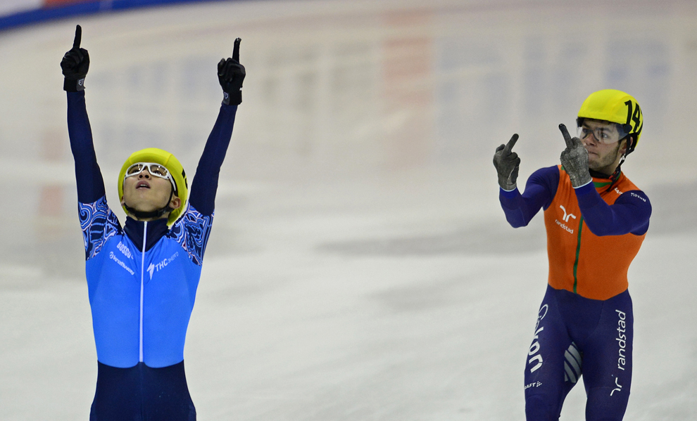 Sjinkie Knegt (D) din echipa Olandei gesticulează la adresa lui Victor An (S) din echipa Rusiei, care sărbătoreşte victoria echipei sale în finala probei de patinaj viteză, în Dresda, Germania, duminică, 19 ianuarie 2014.