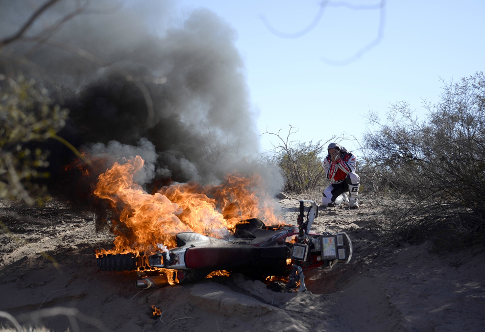 Portughezul Paulo Goncalves îşi urmăreşte motocicleta Honda în flăcări, în timpul etapei a 5-a a cursei Dakar 2014, între Chilecito şi Tucuman, Argentina, joi, 9 ianuarie 2014.