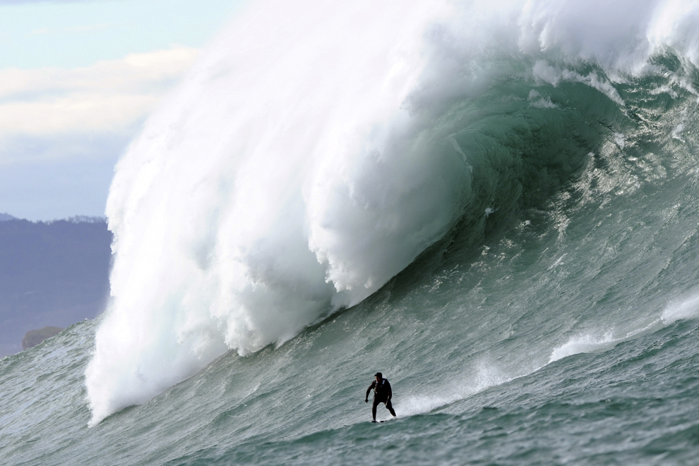 Un bărbat surfează pe un val gigantic în dreptul coastei franceze a localităţii basce Urrugne, marţi, 7 ianuarie 2014.