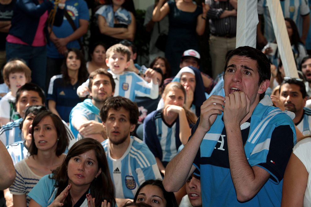 Argentinieni reacţionează în timpul unei transmisiuni în direct din timpul finalei Cupei Mondiale la fotbal FIFA 2014, dintre Germania şi Argentina, la ambasada Argentinei din Mexico City, Mexic, duminică, 13 iulie 2014.