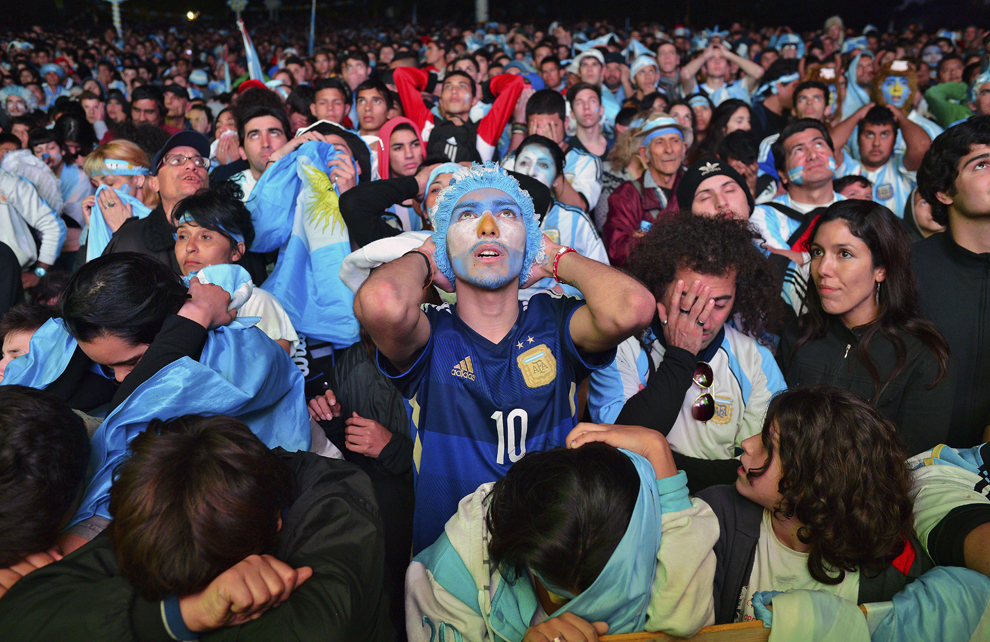 Argentinieni reacţionează în timpul unei transmisiuni în direct din timpul finalei Cupei Mondiale la fotbal FIFA 2014, dintre Germania şi Argentina, în Piaţa San Martin din Buenos Aires, duminică, 13 iulie 2014.